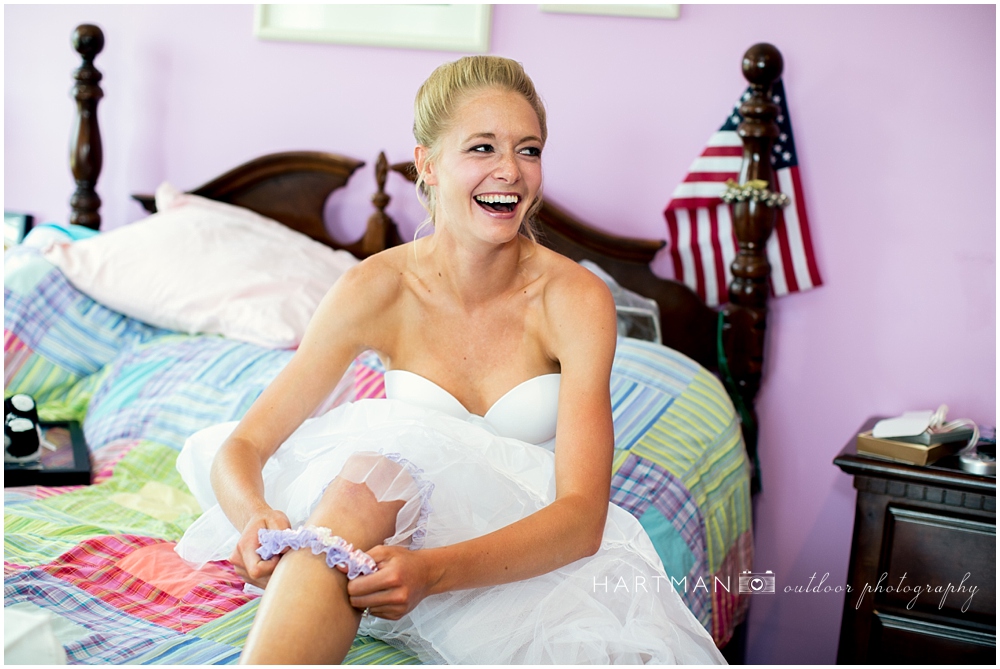 Bride putting purple garter on